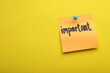Paper note with word Important pinned on yellow background, space for text