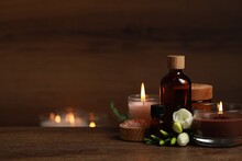 Beautiful Spa Composition With Burning Candles, Different Care Products And Flowers On Wooden Table. Space For Text
