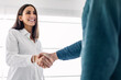 © Westend61 - Happy young businesswoman shaking hand with colleague at workplace