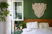 Macrame Decoration Hanging On Green Wall Above Bed In Bedroom