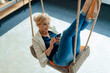 © Westend61 - Businesswoman using mobile phone on swing at workplace