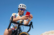 © Westend61 - Happy cyclist using smart phone sitting on bicycle