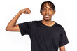 Confident young man showing his arm muscle. Male African American model with brown eyes and afro braids in black T-shirt demonstrating his bicep. Fitness, strength concept