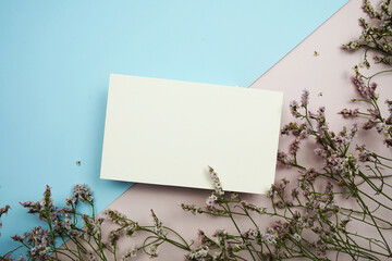 Wall Mural - Empty invitation card mockup with flower bouquet on pink and blue background