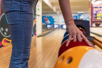  Young asian holding bowling ball, relaxing concept, a man's hand throws a bowling ball close-up, a man plays bowling on the background of the playing