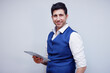 © krongthip - Smiling businessman using tablet on a white background.