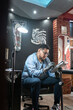 © Miguel Serrano - A tattoo artist is checking out his designs on his work tablet in his studio