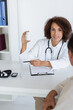 © LIGHTFIELD STUDIOS - Smiling african american doctor holding pills near blurred patient and diabetes kit in hospital