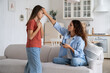 © DimaBerlin - Unhealthy teen girl child complaining of sore throat to mother, mom holding mobile phone touching forehead of schoolgirl checking fever by hand, parent leaving sick kid at home. Influenza in children