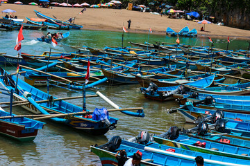 Yogyakarta, Indonesia in October 2022. Local tourists enjoying Baron beach, Gunung Kidul with boat.