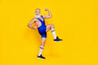 © deagreez - Profile full length photo of handsome strongman grandfather wear sport costume demonstrating biceps leg up isolated on yellow color background