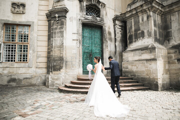 Wall Mural - A loving wedding couple are walking back along the streets of the city of Lviv