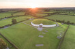 Aerial view of a sunset and surrounding farmland at the ancient passage tomb and temple of Newgrange, a Neolithic monument at the Bru na Boinne Heritage Site; Donore, County Meath, Ireland