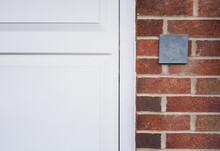 Grey Slate Plaque On A Stone Wall For The Indication Of House Number, Empty Plate Board Hang On Brick Wall Background Or Brown Concrete Block For Replace Number For House Address