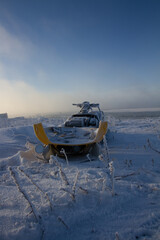 Wall Mural - Old snowmobile sitting on a snow covered landscape, near Churchill, Manitoba, Canada