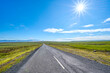 © Designpics - Vast empty road in summer with sunburst in bright blue sky overhead; Austurland, Northern region, Iceland