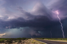 A Barrage Of Lightning Strikes The Ground As A Brief But Large Cone Tornado Crosses The Highway Near Hagerman, New Mexico; Hagerman, New Mexico, United States Of America