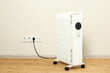 © New Africa - Modern portable electric heater on floor near beige wall indoors, space for text
