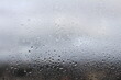 © Mauri - drops on the window with gray sky  in the background and the blurred city. drops of water on the glass. drops of water on window glass.