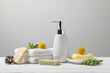 Soap bars, bottle dispenser and towels on wooden table against white background