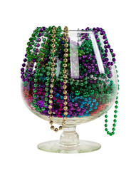 Isolated brandy glass filled with colorful mardi gras beads