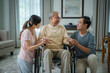 © visoot - Asian senior male sitting at wheelchair with family at home living room,Retired older people,Concept healthcare.