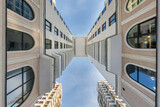 Fototapeta  - view up from ground to blue sky among skyscrapers, look at house from bottom up