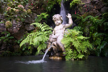 Statue Of A Boy Peeing To A Pond In Monte Palace Tropical Garden, Madeira, Portugal.