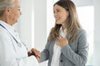 © Panorama - Senior doctor talking with woman patient They are smiling and looking each other
