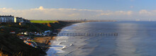 Panoramic Landscape Image Of Saltburn On A Sunny Afternoon With Lots Of People Surfing. Saltburn, North Yorkshire, England, UK.