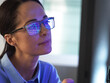 © Connect Images - Female expert in glasses looking at screen with financial data