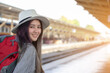 Portrait charming beautiful traveler woman. Young woman traveler waiting for train at train station, Travel and active lifestyle concept. Traveler young woman looking at camera.