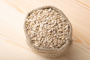 Wall Mural - Peeled sunflower grain in linen sack. Beautiful composition of white peeled sunflower seed in bag