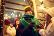 © Lustre Art Group  - Emotional young people, friends meeting, smiling, drinking hot drinks at evening city street at winter time. Emotions, love, friendships, ad, sales concept