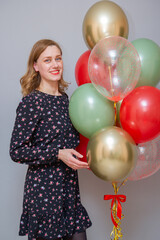 Wall Mural - girl with red lipstick with a bunch of balloons against a gray wall