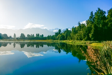 Wall Mural - Reflections in Lake Mathieson surrounded by natural bush and forest and Southern Alps mountain range