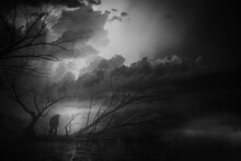 Dark Autumn Landscape Showing A Dramatic Stormy Sky, Silhouettes Of Trees On A Desolate Plain, And A Man Standing	