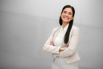 beautiful hispanic business woman, executive, boss, ceo, entrepreneur in a suit, smiling and standin