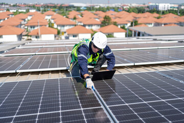 Engineer on rooftop kneeling next to solar panels photo voltaic check laptop for good installation