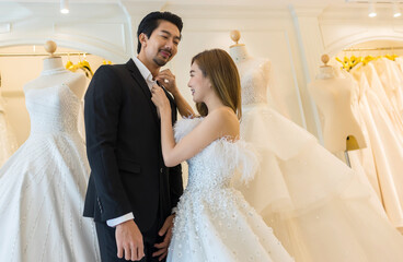 Bride and groom wear dress and try to fitting in wedding studio 