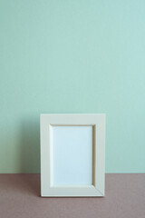 Wall Mural - Blank picture frame on table. mint wall background. copy space