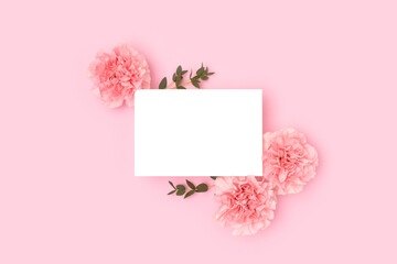 Wall Mural - clean paper card mock up, carnation flowers and green eucalyptus branches on a pink background. gree