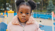© Yuliia - Close up serious child face portrait cute little African American kid sad upset close-up alone small girl baby daughter looking at camera calm ethnic child after school standing at playground outdoors