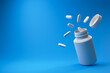 White pills and plastic medical container on a blue background. Medicine and health concept. 3d rendering.