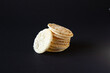 Stack of puffed chips on black background with a chip leaning on stack, 100% Healthy Snacks 