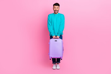 Sticker - Full body length photo of young excited smiling cheerful guy enjoy his first trip stay railway station with luggage isolated on pink color background