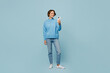 © ViDi Studio - Full body young smiling happy woman wear knitted sweater look camera hold in hand use mobile cell phone isolated on plain pastel light blue cyan background studio portrait. People lifestyle concept.
