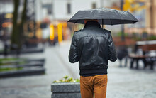 Alone Man With Umbrella. Man With Umbrella Walk On City Street On Rainy Day. Back View Of Stylish Man In Rainy Weather.