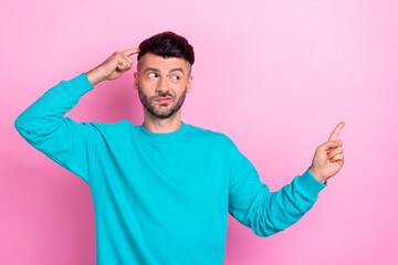 Wall Mural - Photo of young dissatisfied pensive minded guy brunet hair finger temple head direct empty space bad choice company isolated on pink color background