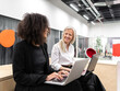 © ADDICTIVE STOCK - Smiling diverse female office workers using laptops at work